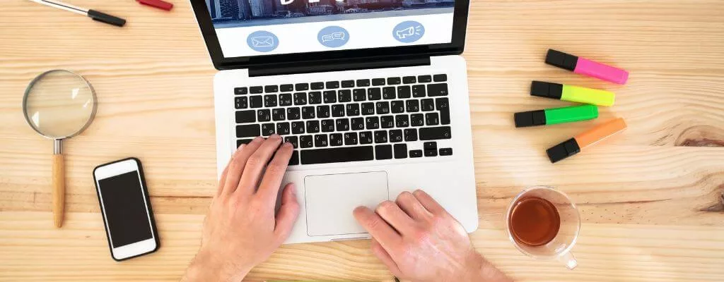 Blogging for business. A top view image of mens hands typing on a laptop computer.